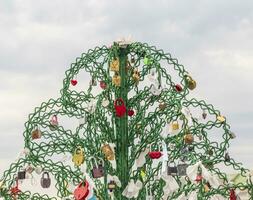 Metal tree structure where couples locking the locks as a sign of true love. Concept photo