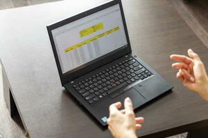 Shot of a woman working on the laptop showing an excel sheet on the screen with bank loan amortization table. Accounting photo