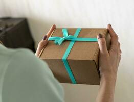 Close up shot of the woman holding wrapped gift box. Holiday photo