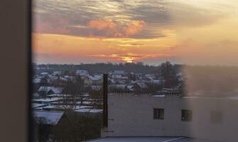 Disparo de el dramático puesta de sol en el rural ciudad en el frío Mañana. temporada foto