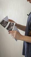 Shot of the female doctor in uniform against the white wall studying ultra sound image. Healthcare photo