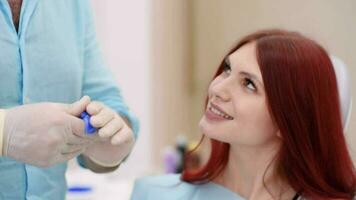 The orthodontist crumples the silicone material for the impression tray that will be placed in the patient's mouth to shape her teeth video