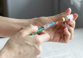 Close upshot of the woman preparing medicine for injection. Healthcare photo