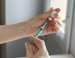 Close upshot of the woman preparing medicine for injection. Healthcare photo