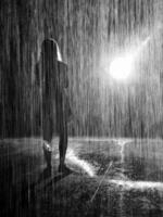 Concept black and white shot of the woman under the pouring rain. Concept photo