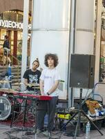 Moscow, Russia - 08.10.2023 - Visitors enjoying street band performance at Arbat street. City photo