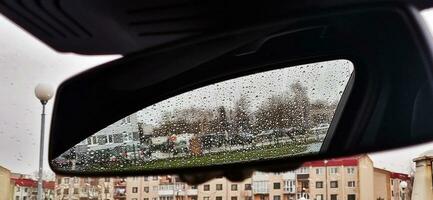 concepto Disparo de el coche ventana cubierto por lluvia gotas. antecedentes foto