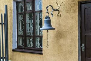 Concept shot of an old railway station with the bell on the wall. Vintage photo