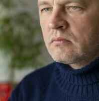 retrato de el medio Envejecido hombre con gris cabello, vistiendo cálido, oscuro azul suéter. personas foto