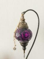 Close up shot of the decorative lamp with pieces of jewelry on it. Concept photo