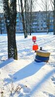 paisaje Disparo de el calle en el invierno día. niños patio de recreo cubierto en nieve. temporada foto