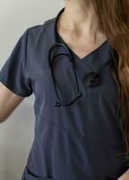 Shot of the female doctor in uniform against the white wall. Healthcare photo