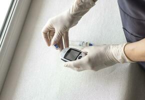 Close up shot of the glucometer instrument on the white surface. Healthcare photo