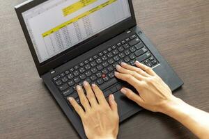 Shot of a woman working on the laptop showing an excel sheet on the screen with bank loan amortization table. Accounting photo