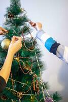 cerca arriba Disparo de mujer y pequeño chico decorando Navidad árbol. fiesta foto