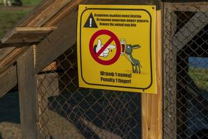 Funny signboard on Belarus and English languages placed in the zoo. Humor photo