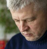 retrato de el medio Envejecido hombre con gris cabello, vistiendo cálido, oscuro azul suéter. personas foto