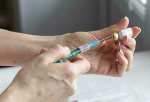 Close upshot of the woman preparing medicine for injection. Healthcare photo