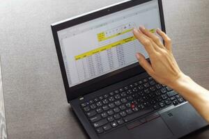 Shot of a woman working on the laptop showing an excel sheet on the screen with bank loan amortization table. Accounting photo