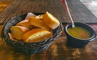 Bread in basket and green coriander sauce restaurant Mexico. photo