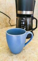 Blue coffee cup and black coffee maker from Mexico. photo