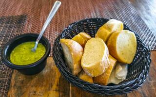 Bread in basket and green coriander sauce restaurant Mexico. photo