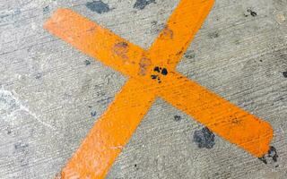 Orange painted cross on the sidewalk Playa del Carmen Mexico. photo