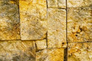 Rough yellow brick wall texture pattern in Coba Mexico. photo