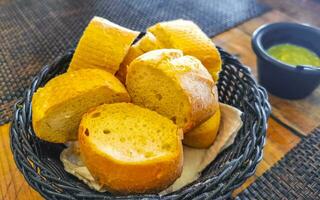 Bread in basket and green coriander sauce restaurant Mexico. photo