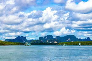 Tropical paradise turquoise water beach limestone rocks fisherboats Krabi Thailand. photo