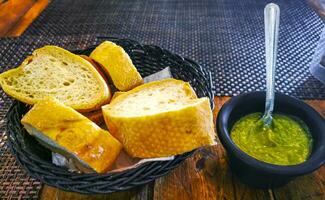 Bread in basket and green coriander sauce restaurant Mexico. photo