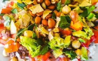 Vegetable dish with carrots peas onions beans on white plate. photo