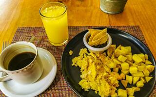 Breakfast scrambled eggs spinach fruit potatoes nicely arranged on plate. photo