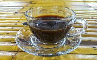 Glass Cup of black coffee on wooden bamboo table Thailand. photo