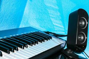 Keyboard and black speaker in front of blue wall Germany. photo