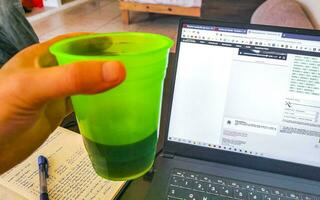 Playa del Carmen Quintana Roo Mexico 2023 Laptop work at table with coffee cup in Mexico. photo