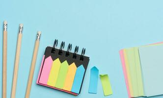 Multi-colored paper sticky notes on a blue background photo