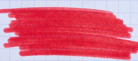 Hatching with a red felt-tip pen on a sheet of checkered paper photo