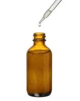 A glass brown bottle with a dropper on a white isolated background, a container for cosmetic products. photo