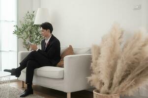 An asian groom using smartphone in wedding day concept of Wedding party photo