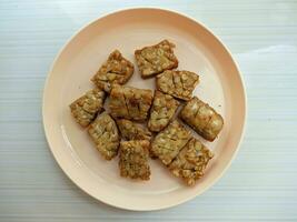 squares of fried tempeh on a plate photo