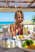 Cute girl drinking cocktail on the beach photo