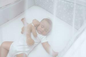 Adorable child sleeping with soft toy photo