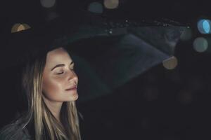 Woman enjoying rainy night photo