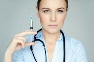 Serious doctor with syringe photo