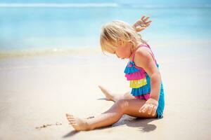 Baby girl playing on the beach photo