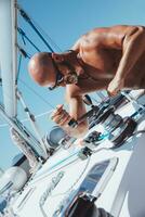 hermoso hombre marinero trabajando en velero foto