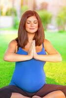 embarazada mujer comprometido en yoga al aire libre foto