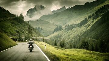 Motorcyclist on mountainous highway photo