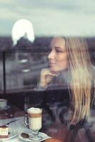 Dreamy girl with latte in cafe photo